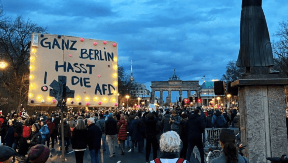 Demonstration am Brandenburger Tor mit Lichtern und Plakaten gegen Rechtsruck